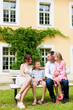 Family sitting in front of their home Family sitting in front of their home
