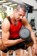 Young man lifting weights in the gym