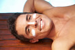 Lachender Mann mit Sonnencreme
