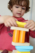 enfant empilant des formes en bois
