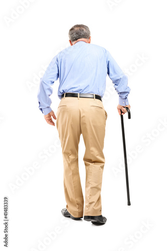 Photo: Full length portrait of a senior man with cane walking Full length portrait of a senior man with cane walking