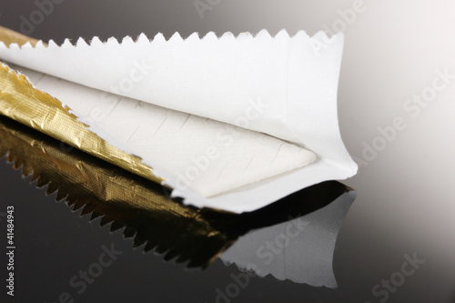 Photo: Chewing gum on the wrapping foil on gray background Chewing gum on the wrapping foil on gray background