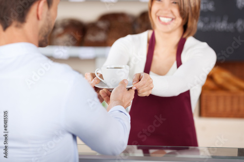 Photo: kunde bekommt eine tasse kaffee in der bäckerei kunde bekommt eine tasse kaffee in der bäckerei