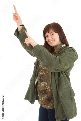 Foto: smiling pointong up teenage girl in militry jacket smiling pointong up teenage girl in militry jacket