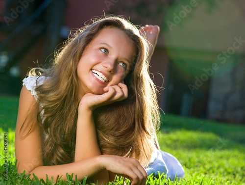 Foto: Beautiful Girl lying on the Field. Happiness Beautiful Girl lying on the Field. Happiness