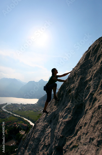 Photo: Silhouette of female climber against view of Lake Garda, Italy Silhouette of female climber against view of Lake Garda, Italy