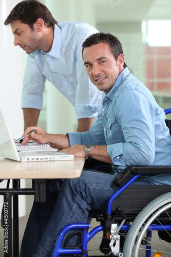 Photo: Man in wheelchair at desk Man in wheelchair at desk