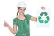 Female construction worker with a recycle sign