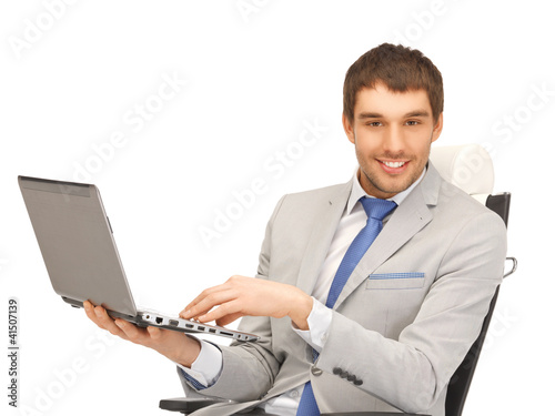 Photo: young businessman sitting in chair with laptop young businessman sitting in chair with laptop