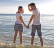 Foto: Young attractive couple standing in the water on the beach Young attractive couple standing in the water on the beach