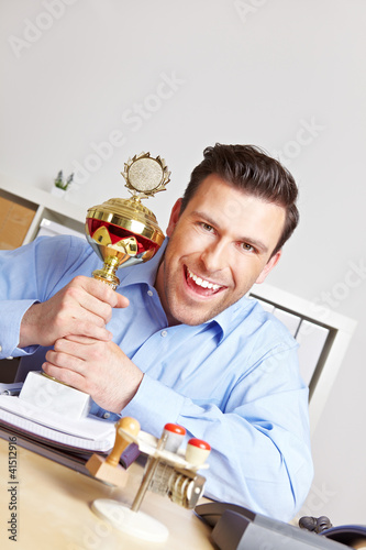 Photo: Jubelnder Geschäftsmann mit Pokal Jubelnder Geschäftsmann mit Pokal