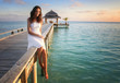Foto: Sexy beautiful young summer girl sitting on a jetty (Maldives) Sexy beautiful young summer girl sitting on a jetty (Maldives)
