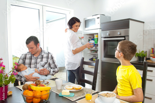 Foto: Hausfrau morgens mit Familie in der Küche Hausfrau morgens mit Familie in der Küche