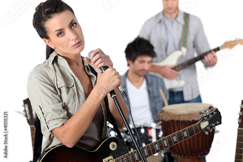 Photo: singer with guitar and microphone and male musicians singer with guitar and microphone and male musicians