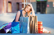 Young shopper sitting on a sidewalk