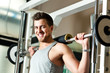 Young man lifting weights in the gym