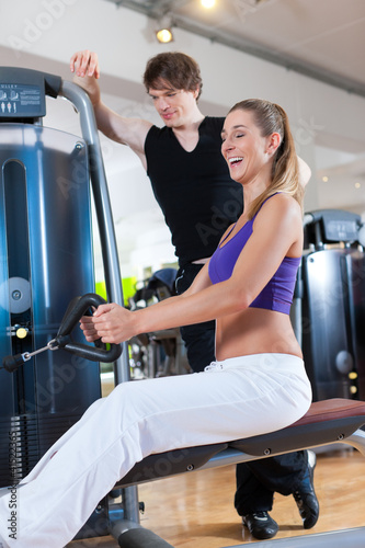 Photo: Sport - Paar trainiert an Kraftmaschinen im Fitnessstudio Sport - Paar trainiert an Kraftmaschinen im Fitnessstudio