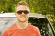 Photo: young man smiling about car young man smiling about car
