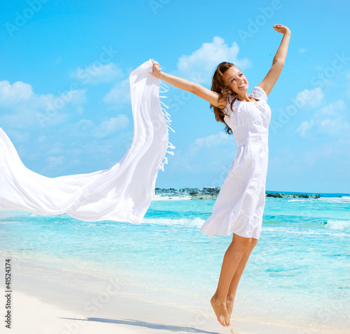 Foto: Beautiful Girl With White Scarf Jumping on The Beach Beautiful Girl With White Scarf Jumping on The Beach
