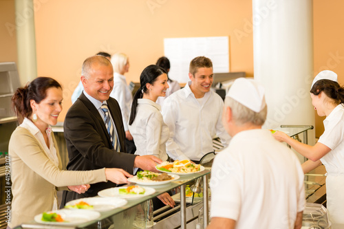 Photo: Business colleagues cook serve lunch canteen food Business colleagues cook serve lunch canteen food