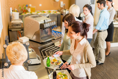 Photo: At the cafeteria woman pay bill At the cafeteria woman pay bill