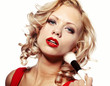 Beautiful blond woman applying makeup on her face