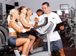 sport coach timing cyclist on gym bike