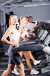 group of fitness people running on treadmill in gym