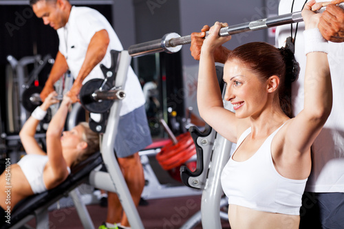 Photo: fitness woman with personal trainer in gym fitness woman with personal trainer in gym