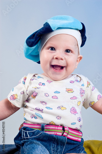 Photo: Amusing baby boy in a beret in a studio on a dark blue backgroun Amusing baby boy in a beret in a studio on a dark blue backgroun