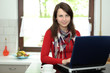 Photo: Junge Frau in der Küche am Laptop Junge Frau in der Küche am Laptop
