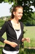 Beautiful young woman running in a park