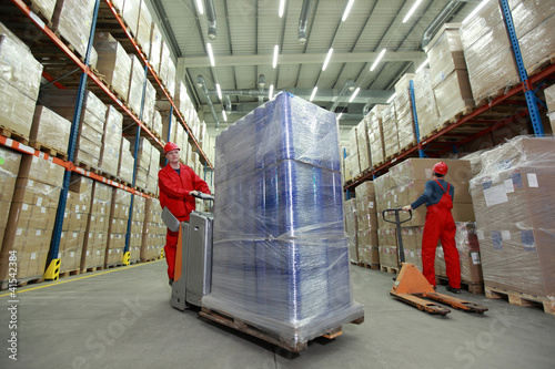 Photo: warehousing - workers in uniforms working in storehouse warehousing - workers in uniforms working in storehouse