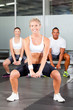 group of people doing fitness exercise with dumbbell in gym