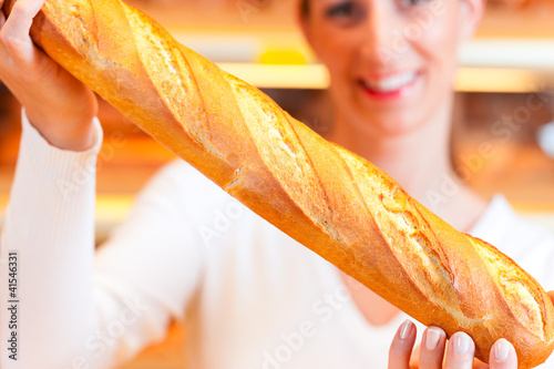 Photo: Bäckerin in ihrer Bäckerei verkauft Brot Baguette Bäckerin in ihrer Bäckerei verkauft Brot Baguette