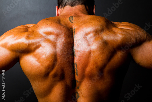 Photo: muscular bodybuilder's back on black background muscular bodybuilder's back on black background