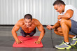 fitness man and personal trainer in gym doing push-ups