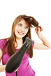 Beautiful smiling young woman drying her hair with drier