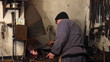 Blacksmith at work, melting iron in a small furnace