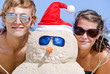Portrait of couple having fun at beach with sandman