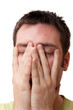 Young man holding hands on his face