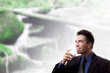 Wasser trinkender Mann vor Bachlauf