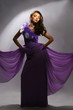 beautiful woman in the purple dress on a gray background