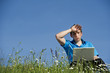 Business Mann sitzt in der Wiese mit Laptop