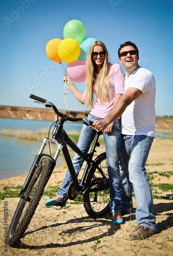 Photo: Happy smiling couple on bicycle Happy smiling couple on bicycle