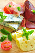 Käse und Schinken auf einer Holzplatte Käse und Schinken auf einer Holzplatte