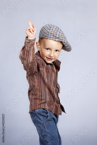 Photo: A little kid at motion. He looks straight to lens. A little kid at motion. He looks straight to lens.