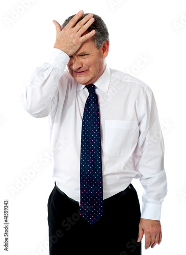 Photo: Sad old corporate man with hand on head Sad old corporate man with hand on head