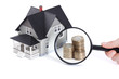 Stacks of coins in front of house architectural model