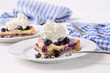 Blueberry lemon tart with whip cream on wood table Blueberry lemon tart with whip cream on wood table